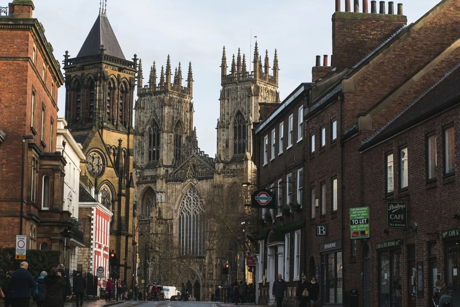 View of York Minster from ground level, the Minster is framed by both side of an adjecent street